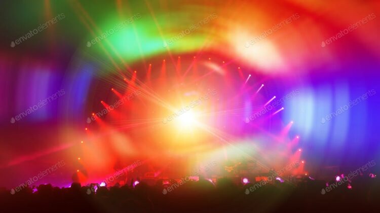 Party background, people enjoying concert, dancing in the night club with colorful lights on the stage, celebrating new year